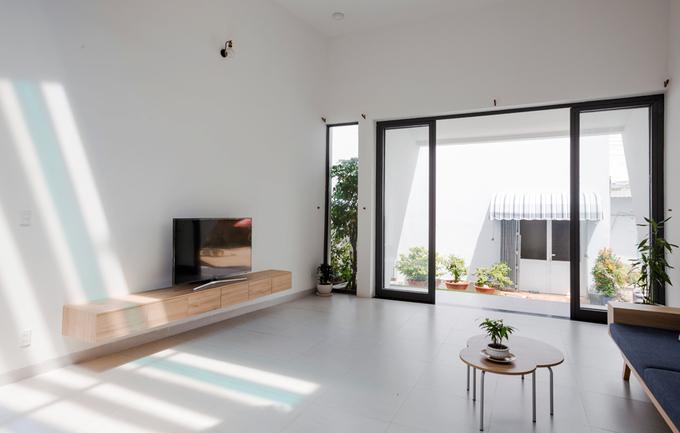 Công trình nằm trong khu của một đại gia đình nên chủ nhà có thể thoải mái mở cửa suốt ngày. Phần mái hiên rộng giúp che nắng nóng nhưng vẫn để ánh sáng, gió mát thổi vào nhà.